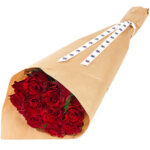 Bukett med röda rosor, omslagspapper runt blommorna. Beställ hos Euroflorist!